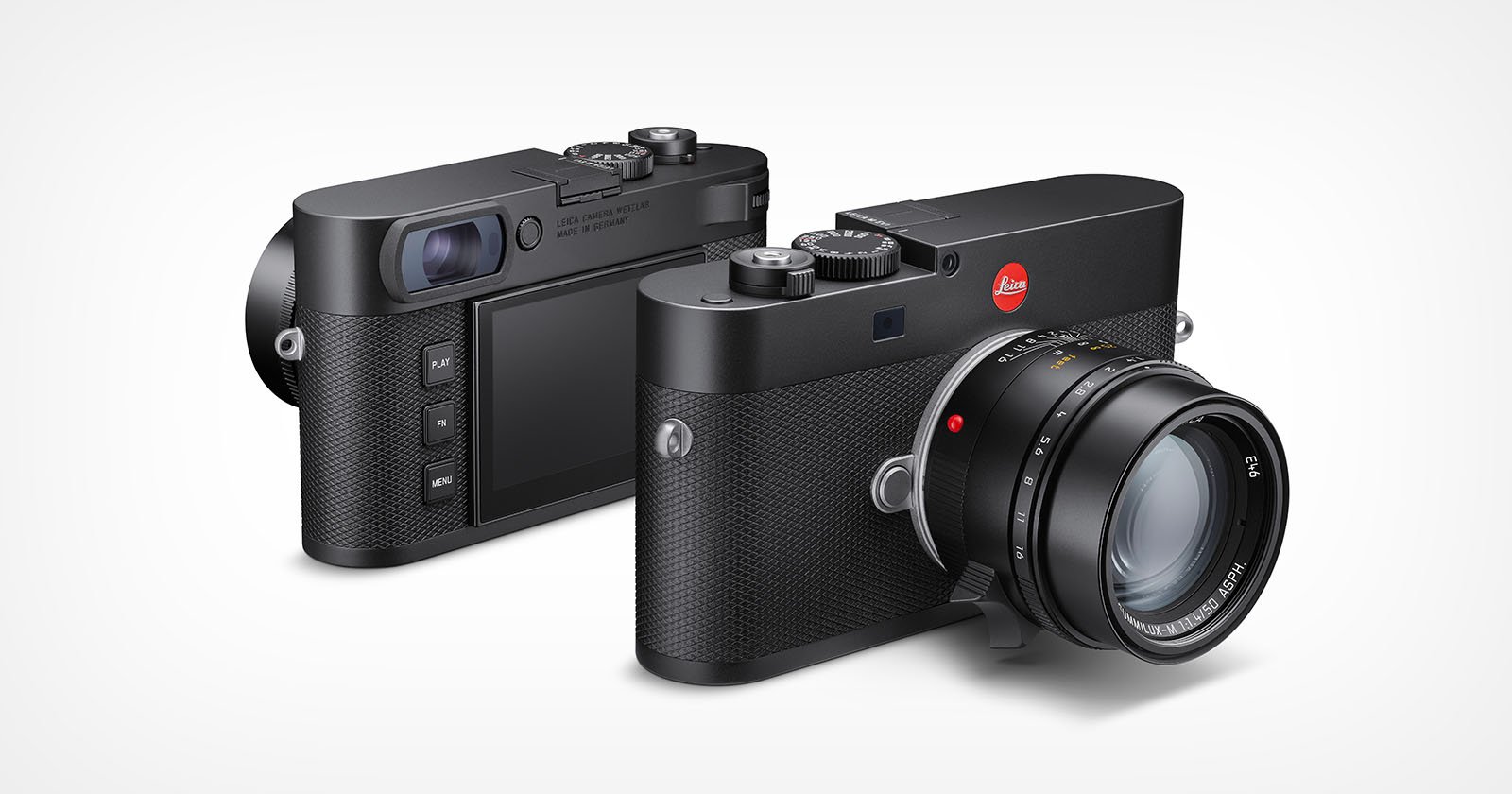 Two black Leica digital cameras are shown, one facing forward displaying the lens and the other turned to show the back with its screen and control buttons. Both cameras have a textured grip and classic, minimalist design. Two black Leica digital cameras are shown, one facing forward displaying the lens and the other turned to show the back with its screen and control buttons. Both cameras have a textured grip and classic, minimalist design.