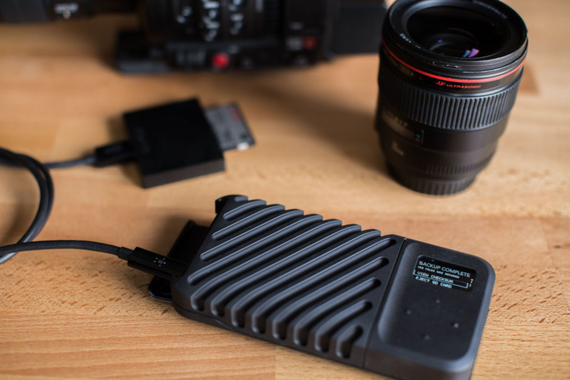 The GNARBOX 2.0 backup device on a table with camera gear