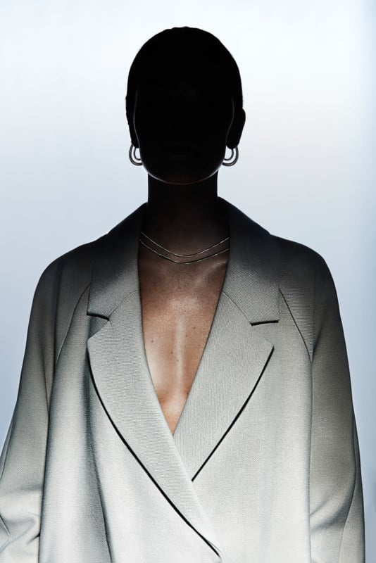 A woman in a fashion photo with her face obscured by shadow