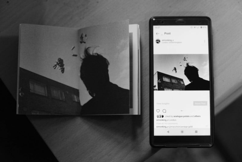 A photo book and smartphone both showing the same photo of a silhouetted man A photo book and smartphone both showing the same photo of a silhouetted man