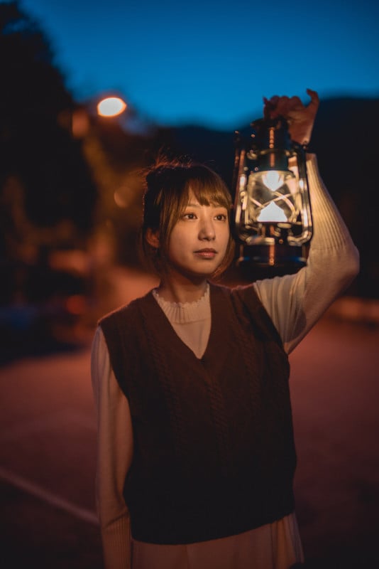 A portrait of a woman holding a lantern at night