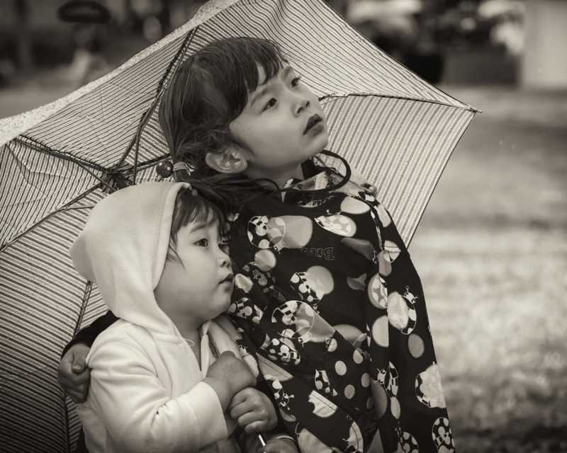 Two children under an umbrella
