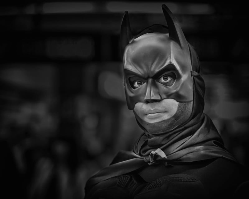 A man wearing a Batman costume and mask