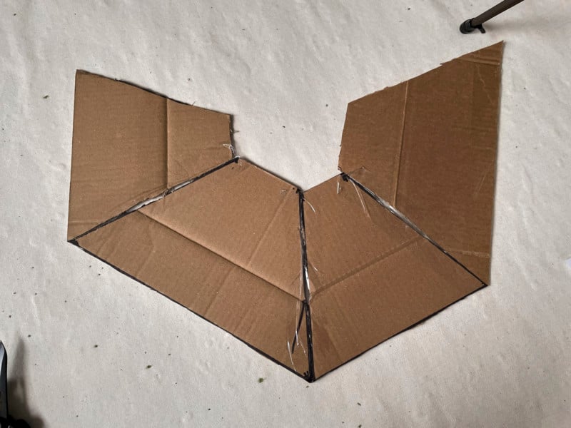 Taping pieces of cardboard together to create the body of a softbox