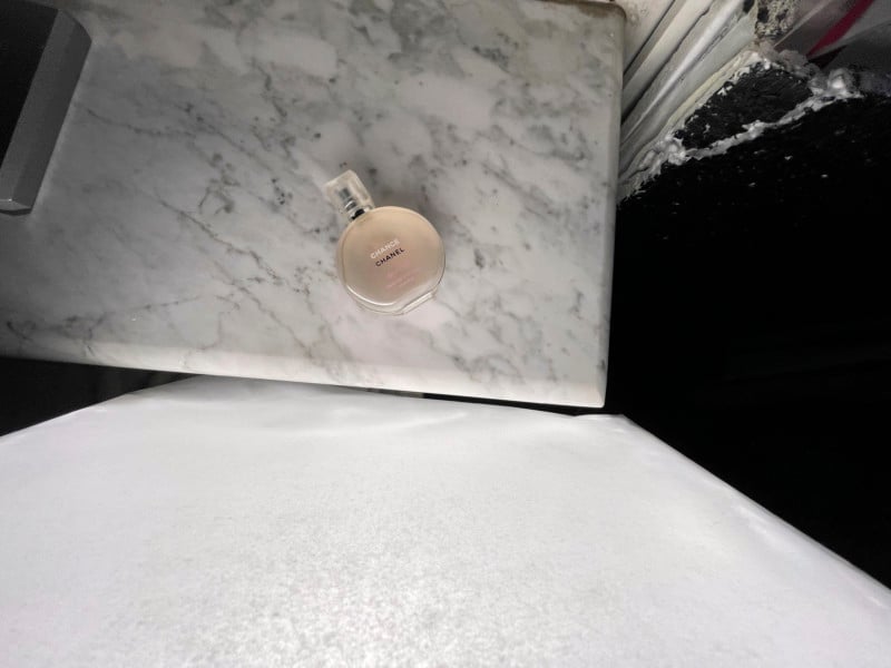 A bottle of perfume on a stone surface A bottle of perfume on a stone surface