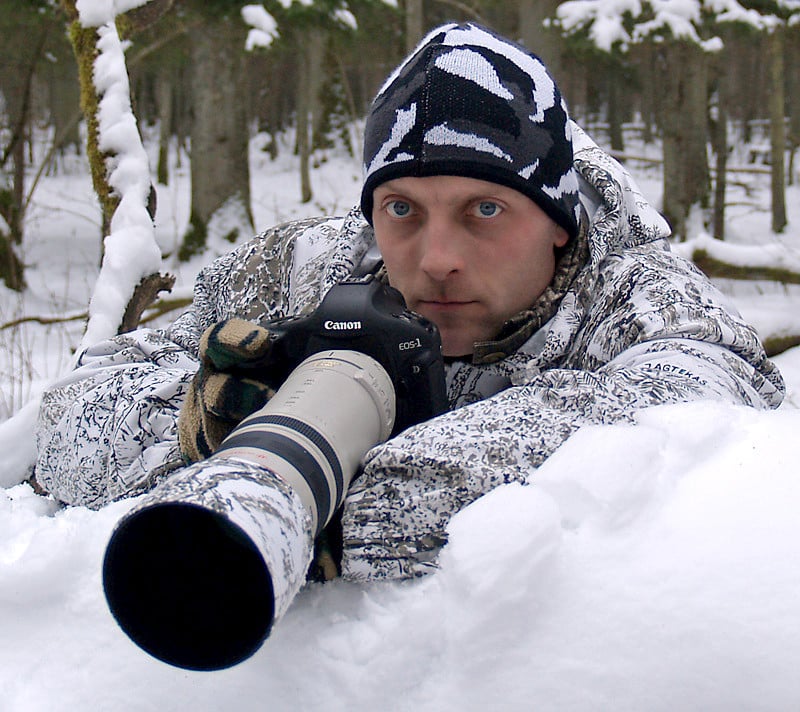 Photographer Renatas Jakaitis with his camera in the snow