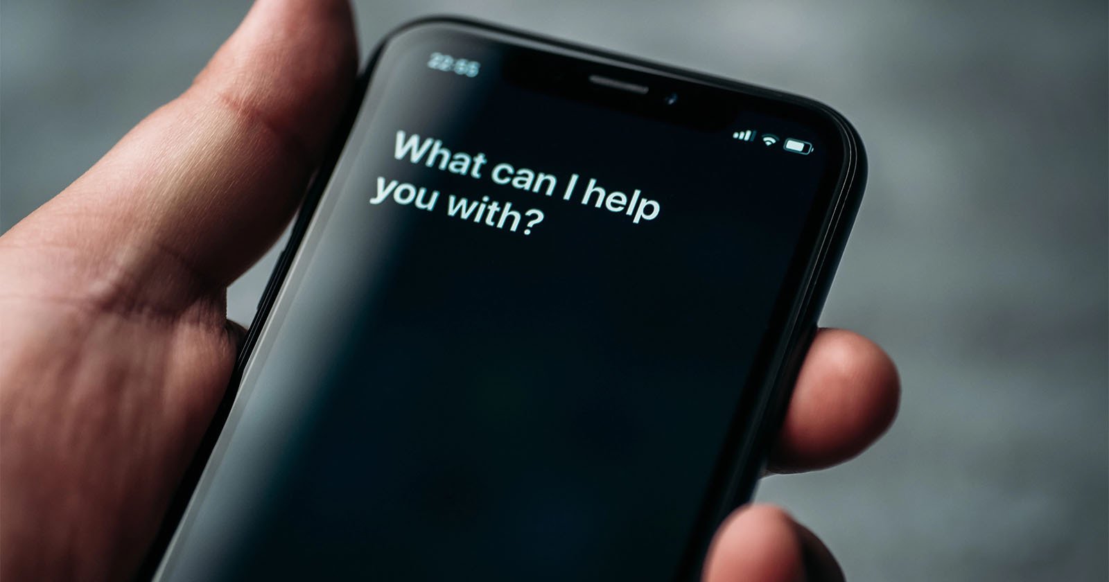 A Siri prompt on an iPhone asks, What can I help you with?