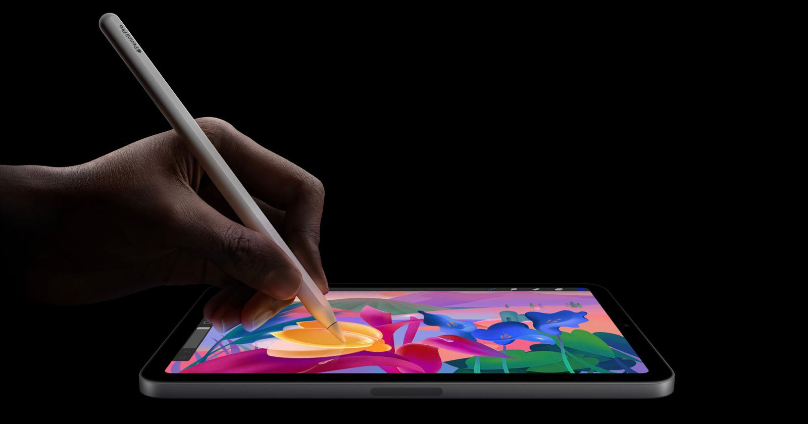 A person uses a stylus to draw colorful flowers on a tablet against a black background. A person uses a stylus to draw colorful flowers on a tablet against a black background.