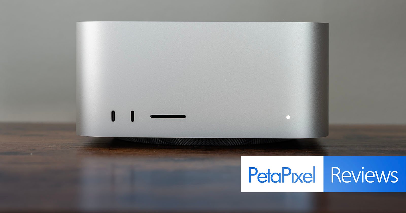 A sleek, silver desktop computer sits on a wooden surface against a plain background. The lower right corner has a PetaPixel Reviews label. A sleek, silver desktop computer sits on a wooden surface against a plain background. The lower right corner has a PetaPixel Reviews label.