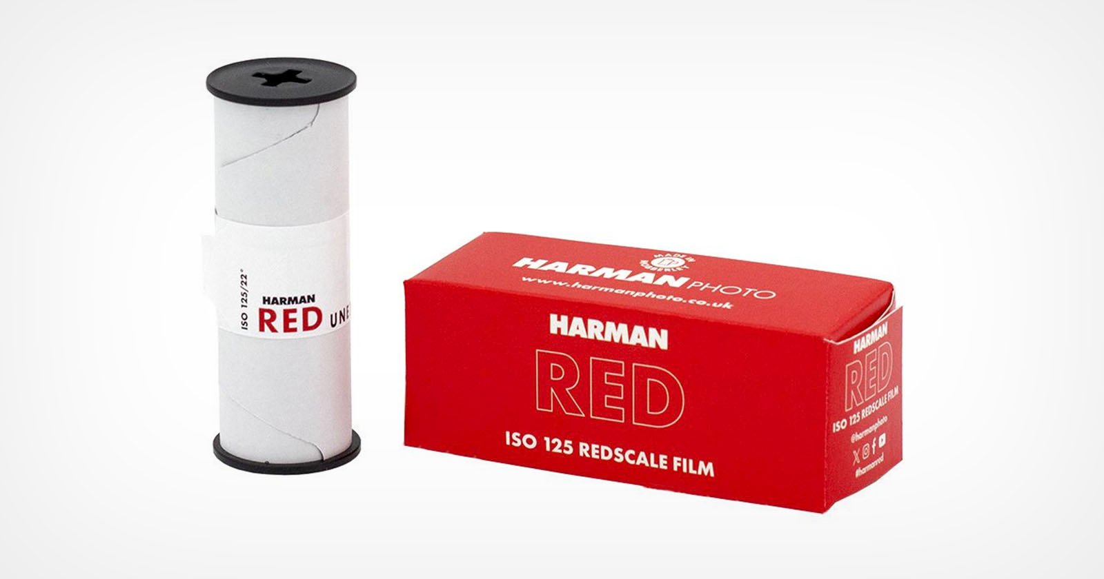A Harman RED ISO 125 redscale film roll stands beside its red and white box labeled Harman Photo RED, ISO 125 Redscale Film on a plain white background. A Harman RED ISO 125 redscale film roll stands beside its red and white box labeled Harman Photo RED, ISO 125 Redscale Film on a plain white background.