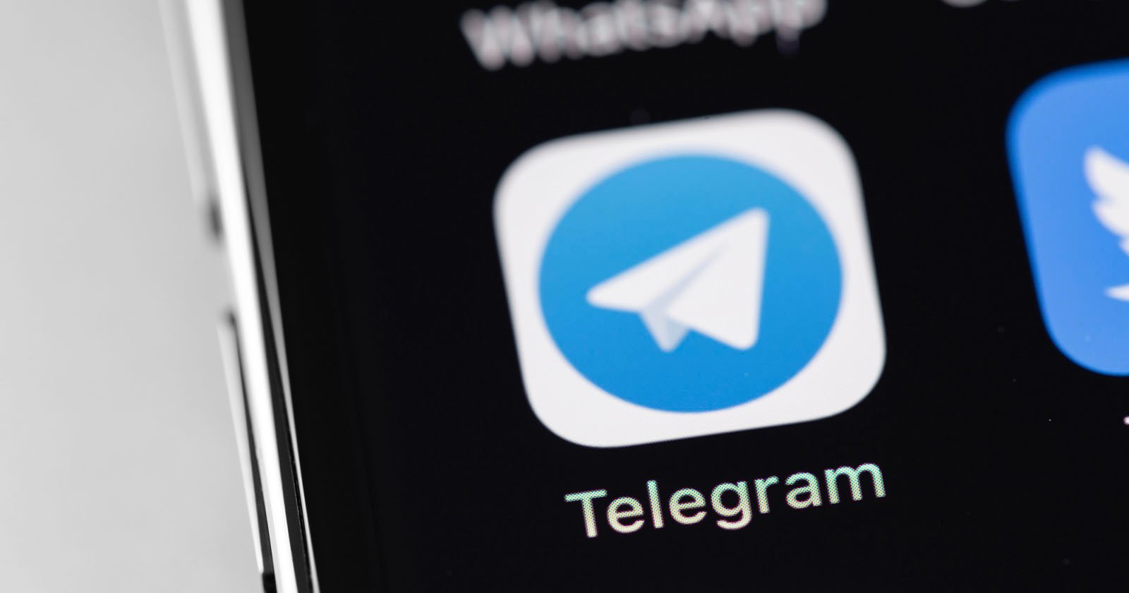 Close-up of a smartphone screen displaying the Telegram app icon, which features a white paper airplane on a blue background, with the word Telegram written below it. Close-up of a smartphone screen displaying the Telegram app icon, which features a white paper airplane on a blue background, with the word Telegram written below it.