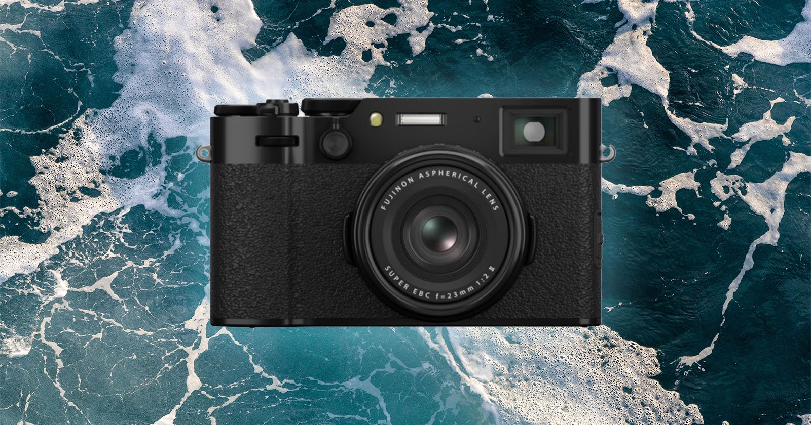 A black digital camera with a textured grip is centered over a background of ocean waves with white foam. A black digital camera with a textured grip is centered over a background of ocean waves with white foam.