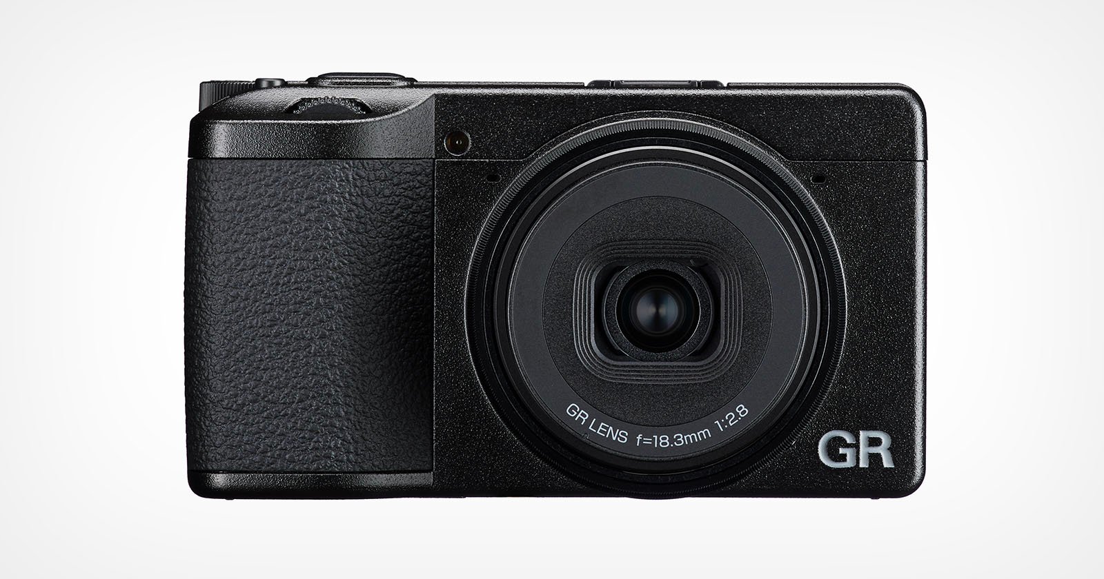 A black compact digital camera with a textured grip, large circular lens labeled GR LENS f=18.3mm 1:2.8, and the letters GR in silver on the bottom right corner of the front. A black compact digital camera with a textured grip, large circular lens labeled GR LENS f=18.3mm 1:2.8, and the letters GR in silver on the bottom right corner of the front.