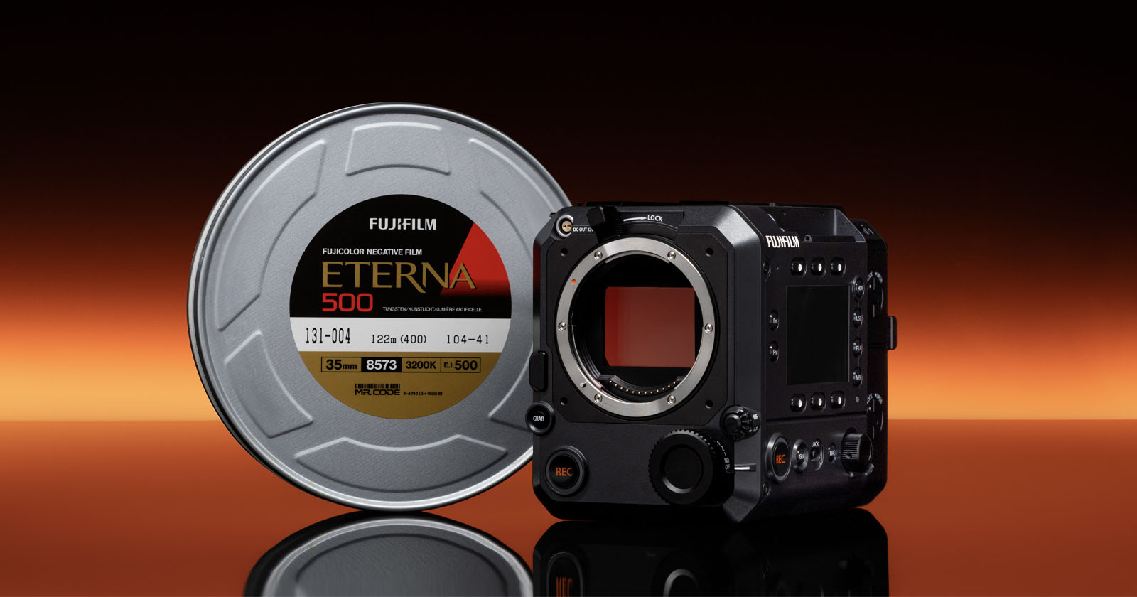 A Fujifilm Eterna 500 film canister stands next to a Fujifilm digital cinema camera body on a reflective surface, with a gradient orange and black background. A Fujifilm Eterna 500 film canister stands next to a Fujifilm digital cinema camera body on a reflective surface, with a gradient orange and black background.