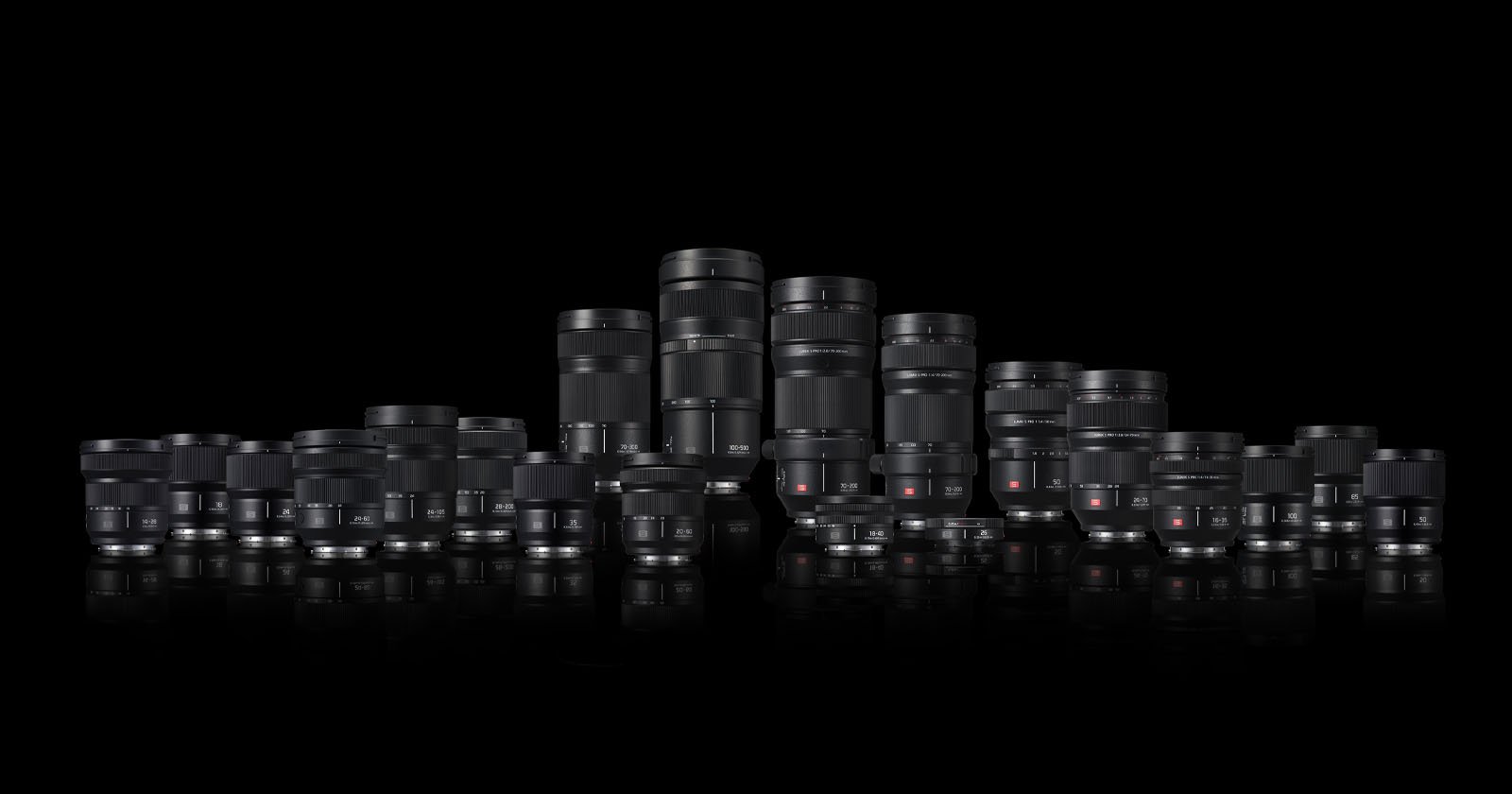 A collection of various camera lenses of different sizes and types arranged in rows against a black background, reflecting slightly on the surface below. A collection of various camera lenses of different sizes and types arranged in rows against a black background, reflecting slightly on the surface below.