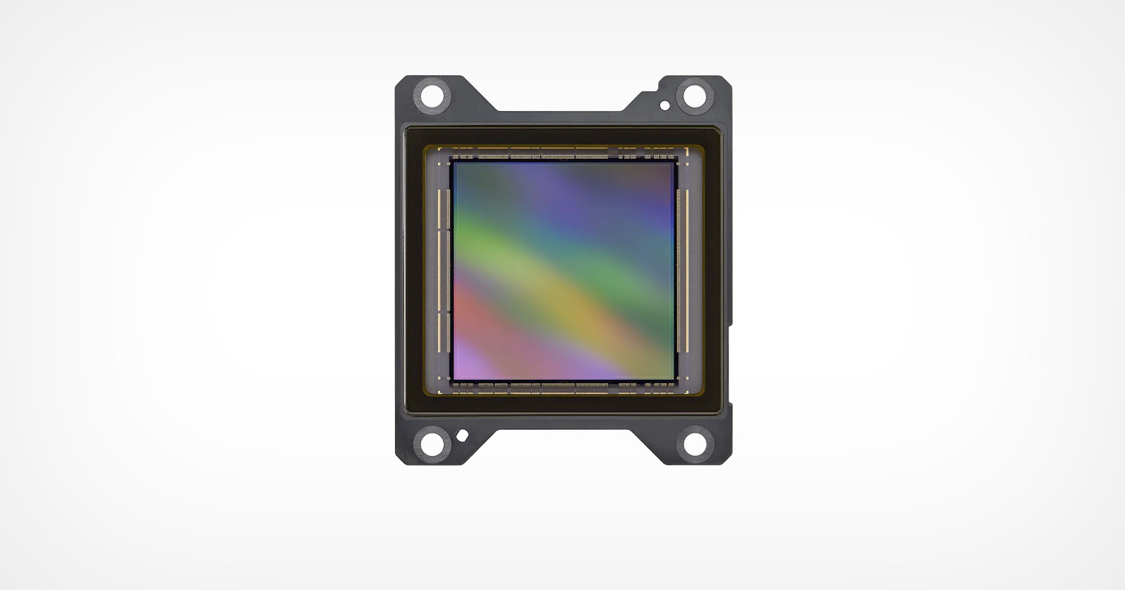 A close-up image of an electronic sensor, likely a camera sensor, with a rainbow-colored reflective surface and four mounting holes, set against a plain white background. A close-up image of an electronic sensor, likely a camera sensor, with a rainbow-colored reflective surface and four mounting holes, set against a plain white background.