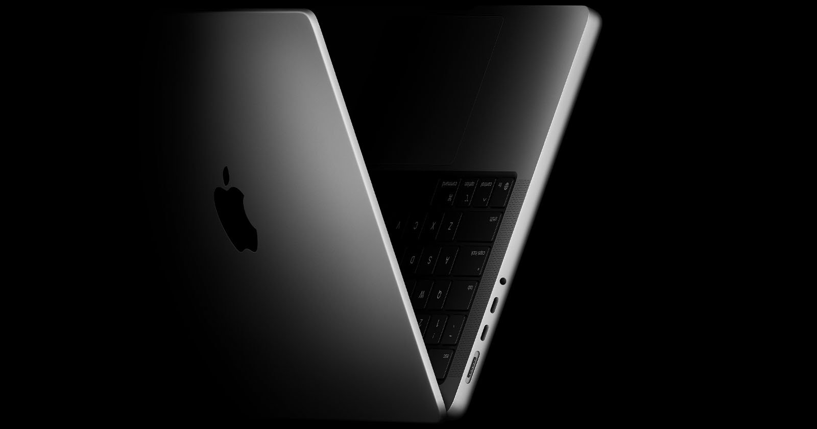 A partially open silver MacBook viewed from the side, showing the Apple logo on the lid, part of the keyboard, and several ports along the edge, set against a black background. A partially open silver MacBook viewed from the side, showing the Apple logo on the lid, part of the keyboard, and several ports along the edge, set against a black background.