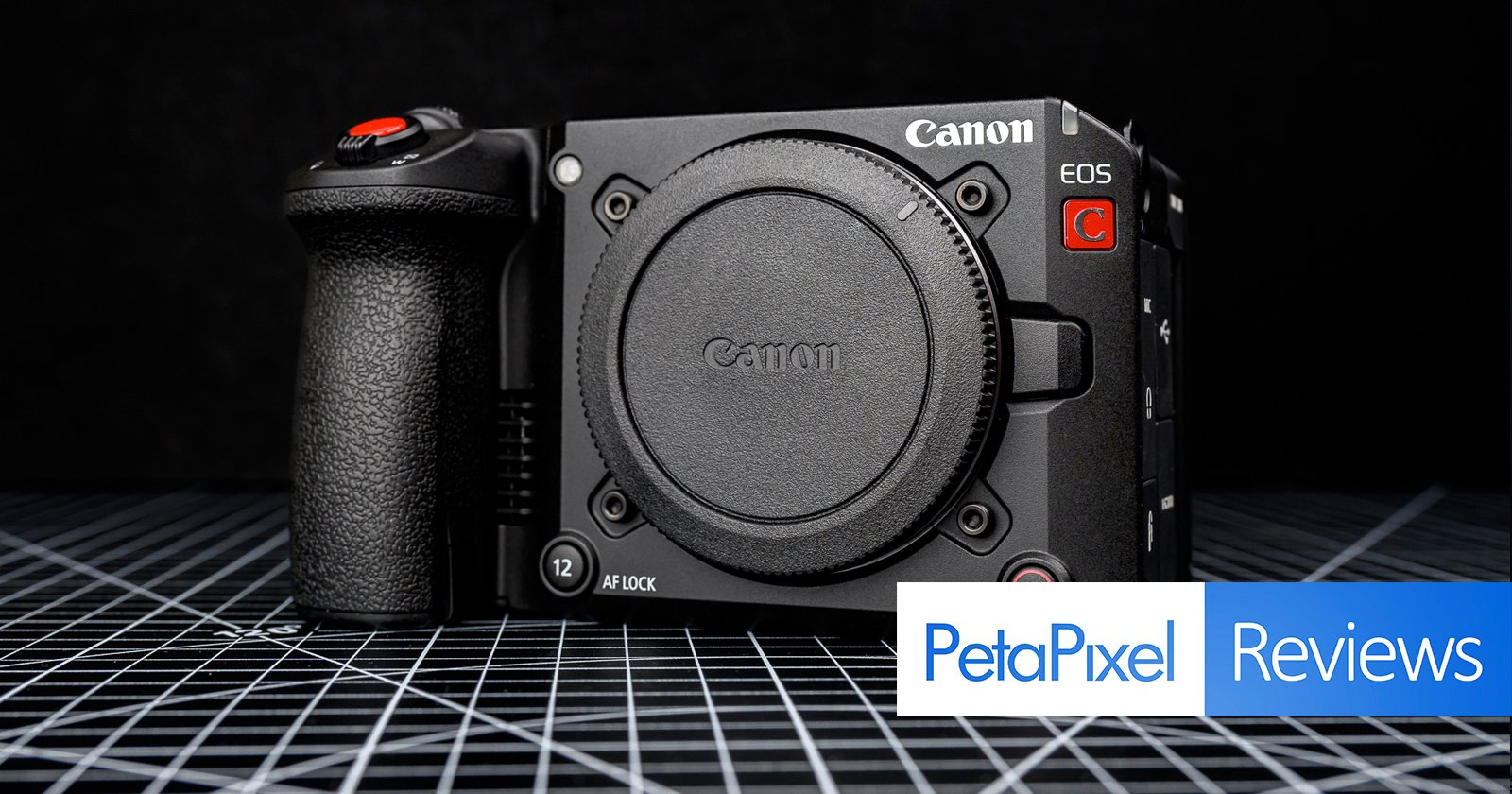 A Canon EOS cinema camera body without a lens is displayed on a grid-patterned surface with the Petapixel Reviews logo in the lower right corner. A Canon EOS cinema camera body without a lens is displayed on a grid-patterned surface with the Petapixel Reviews logo in the lower right corner.
