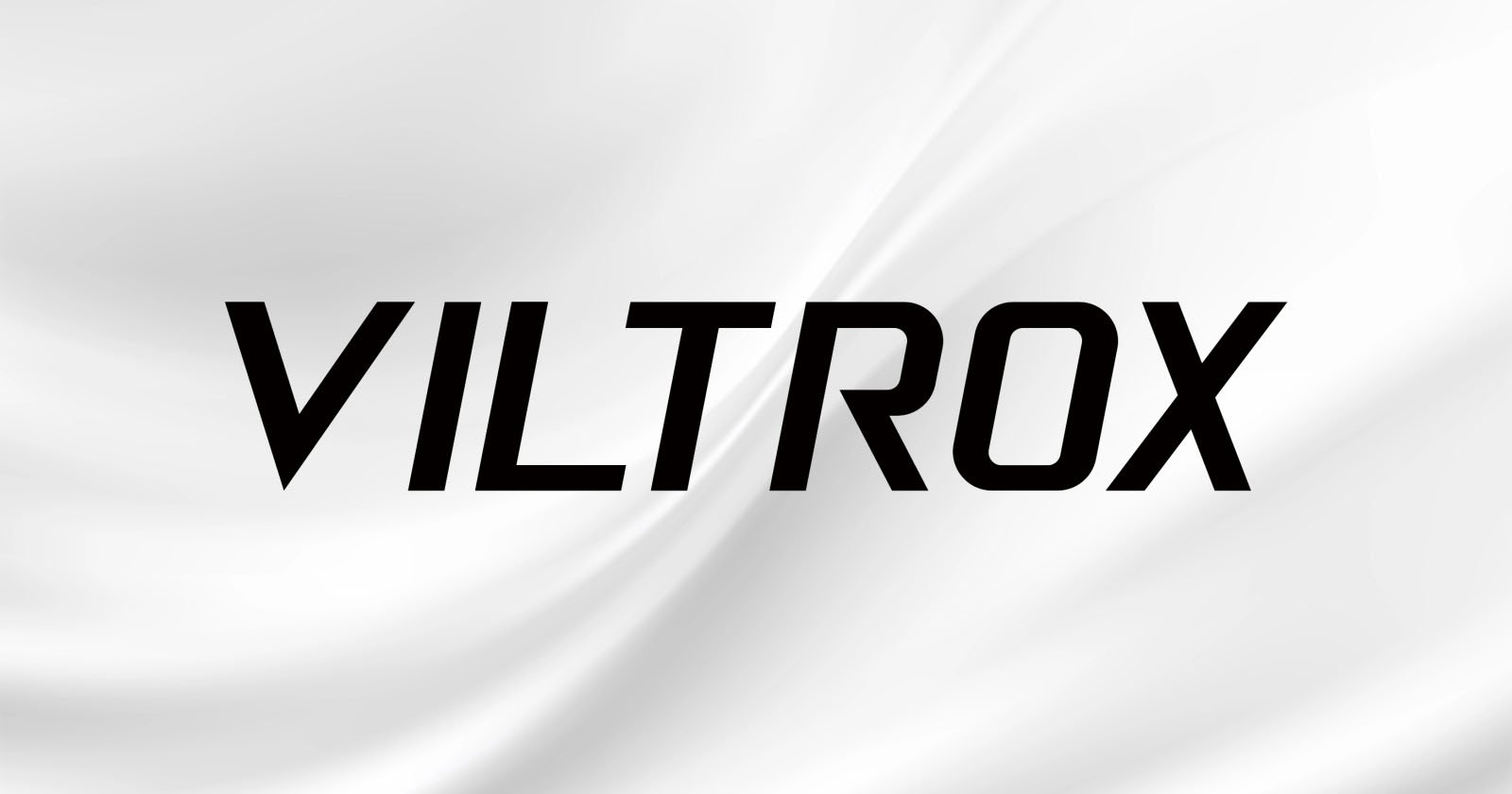 The image features the word VILTROX in bold, black, uppercase letters centered on a white background with soft, flowing wave-like patterns. The image features the word VILTROX in bold, black, uppercase letters centered on a white background with soft, flowing wave-like patterns.